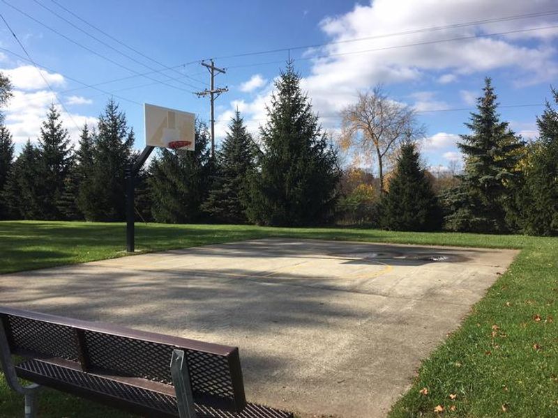 Single hoop basketball court near shelters and playground