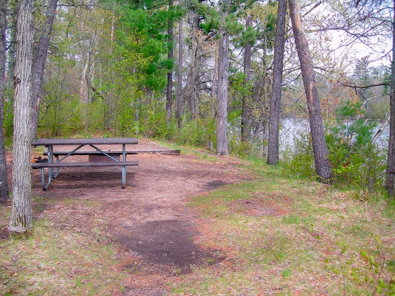 Campsites include a picnic table, fire ring, and a pit toilet.