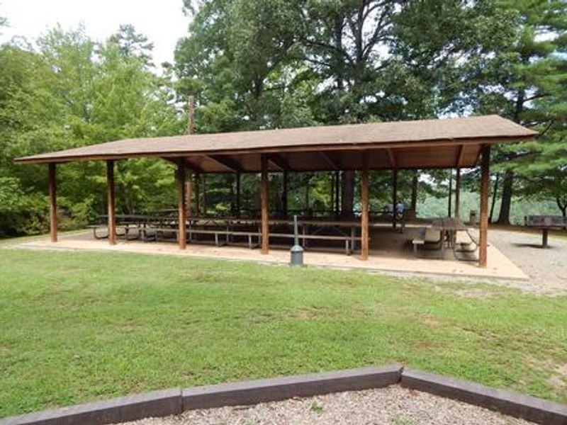 A shelter with picnic tables and barbeque.