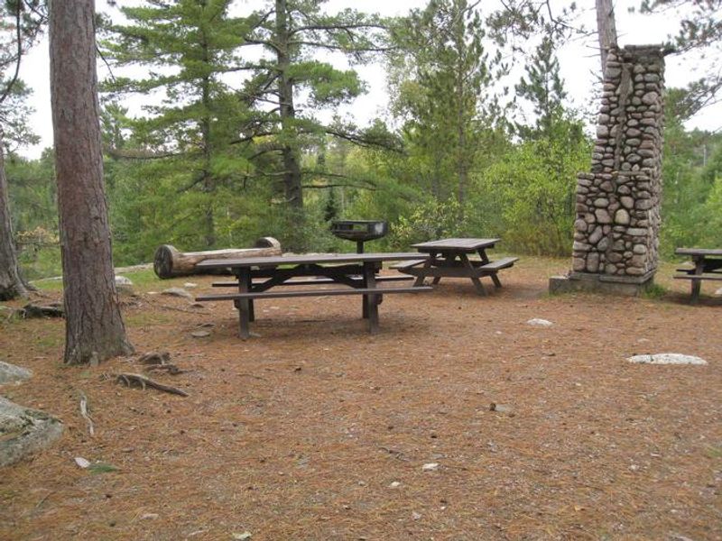 Group camping area with picnic tables and grill.