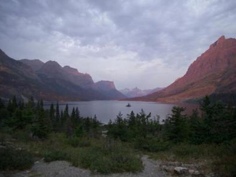 A scenic view of a lake surrounded by rocky peaks