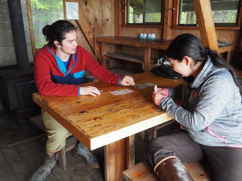 People enjoying card game inside Mallard Slough Cabin