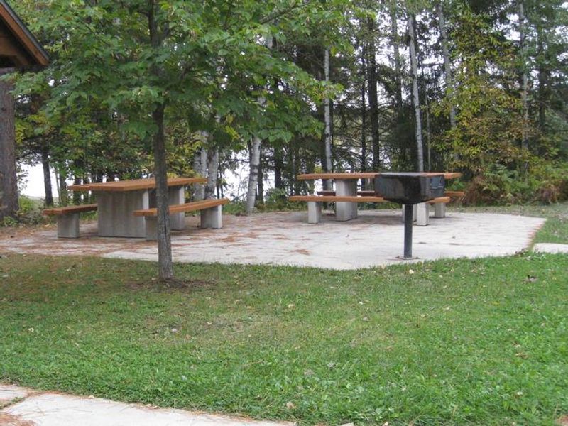Picnic area with tables and grills.  Picnic site is located adjacent to parking area and near beach and play area.