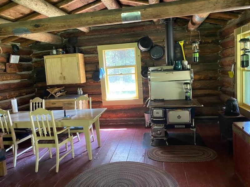 Cabin interior with table, chairs, cookstove