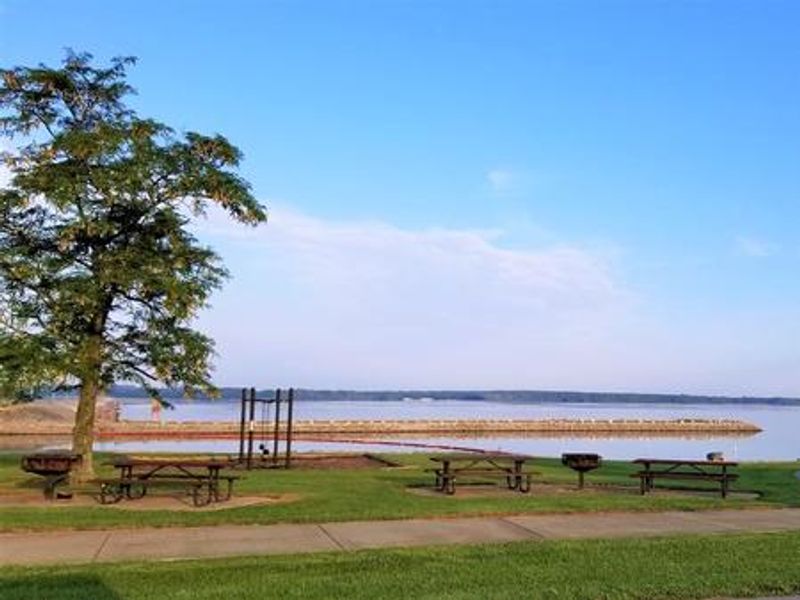 Picnic area and swing set overlooking the lake and spillway.