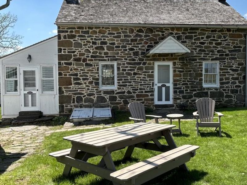 A Picnic Table and Two Adirondack Chairs are Supplied for Outdoor Relaxation