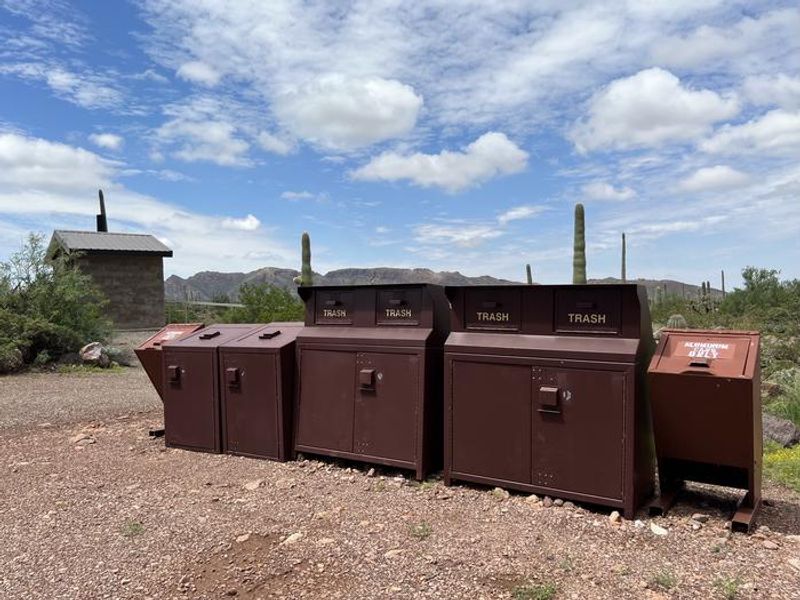 The trash receptacles are located near the restroom.