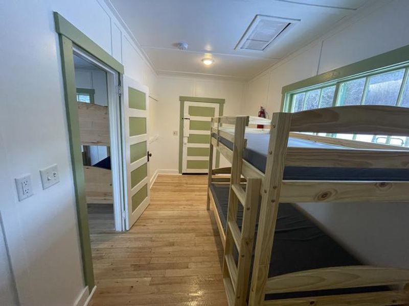 Mudroom contains a bunkbed and cleaning supplies. 