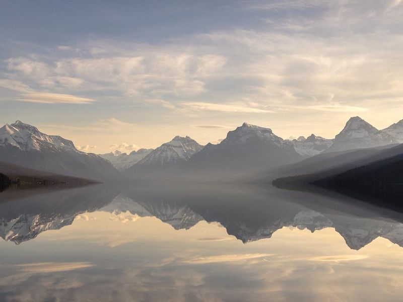 Lake McDonald with mountains in the background and pebble shore in the foreground.
