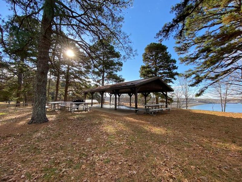 Shelter 5 at Eagle Point. This shelter is handicapped accessible and sits atop a hill with views of the lake. It's in a spacious area, has 8 picnic tables, and is near restroom facilities and playground areas.