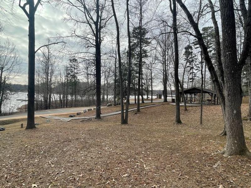 Welcome to Grassy Creek! This is a photo of the reservable shelter along with the parking area located near by. There is a gravel walkway path up to the shelter. 