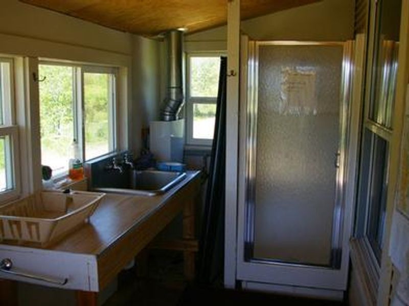 The mudroom has a sink, seasonal shower, and wood storage box. 