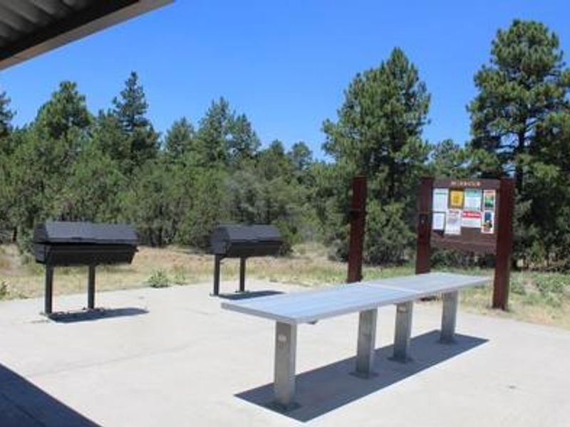 Grills and tables adjacent to group ramada at Timber Camp Equestrian