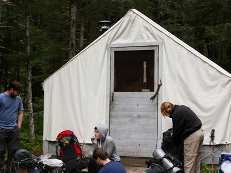 Hikers rest in front of the warming shelter at Pleasant Camp