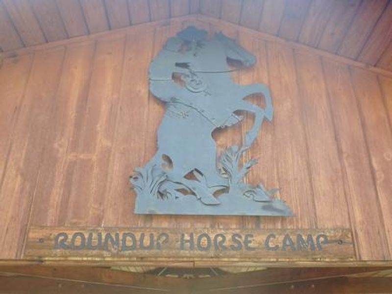 A metal sculpture depicting  a cowboy on a bucking bronco at Roundup Horse Camp